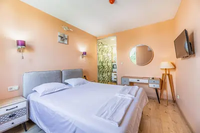 a bedroom with a white bed and a television at Art Hotel Simona in Sofia