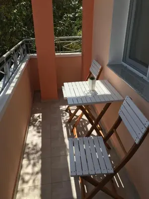 two chairs and a table on a balcony at ФЛАМА РЕЗИДЕНТС in Plovdiv
