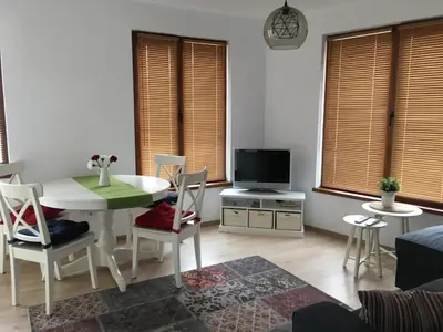a living room with a table and chairs and a tv at Willy Villy's Home- Chepelare in Chepelare