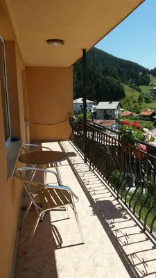 a balcony with chairs and a view of a mountain at Къща за гости МЕЛИСА in Borino