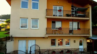 a building with balconies and tables on it at Къща за гости МЕЛИСА in Borino