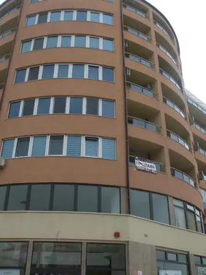 a tall apartment building with a sign on it at Kamy-Sophia Apartment in Sofia