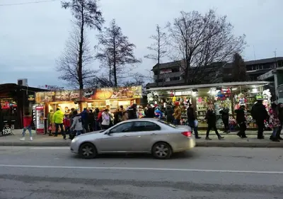 a car driving down a street with a crowd of people at Family 2 bed Apartment in Bansko in Bansko