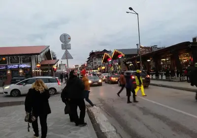 a group of people walking down a busy city street at Family 2 bed Apartment in Bansko in Bansko