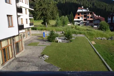 an aerial view of a yard next to a building at Panorama Stoykite Yana apartment in Pamporovo