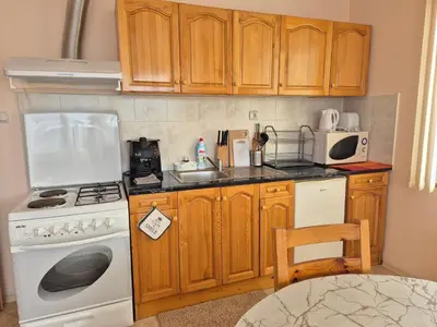 a kitchen with wooden cabinets and a white stove top oven at Panorama Stoykite Yana apartment in Pamporovo