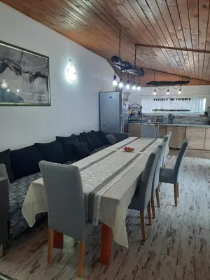 a dining room table with chairs and a couch at Къща за гости Ози in Ovchartsi