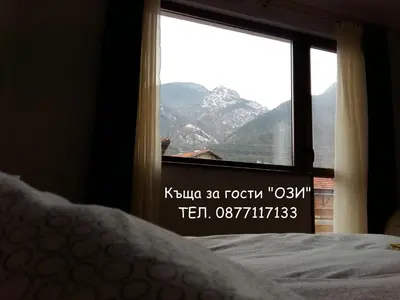 a bedroom window with a view of a mountain at Къща за гости Ози in Ovchartsi