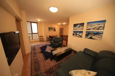 a living room with a couch and a television at Cozy Apartment Next to Gondola in Bansko
