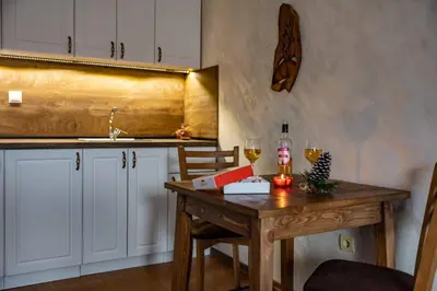 a kitchen with a wooden table with two glasses of wine at Bansko home with a Mountain view in Bansko