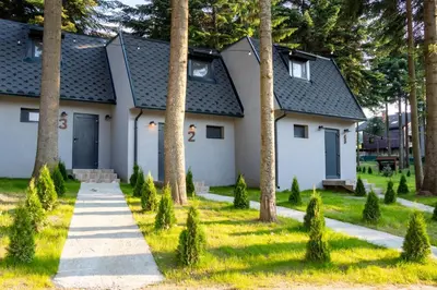 a white house with trees in front of it at Boro Green Holiday Village in Borovets