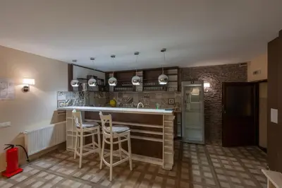 a kitchen with a counter and stools in a room at Къща за гости Пилигрим in Skrino