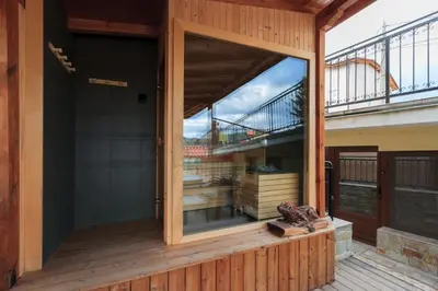 a glass door on a deck with a balcony at Къща за гости Пилигрим in Skrino