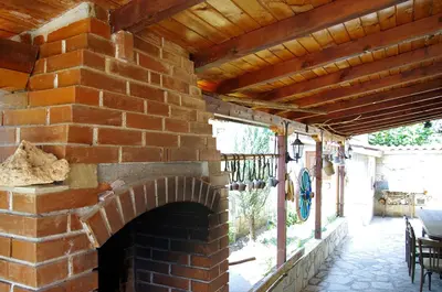 an outdoor brick fireplace with a wooden roof at Complex Diana in Cherven