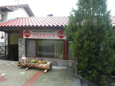 a restaurant with a bench in front of a building at Complex Diana in Cherven