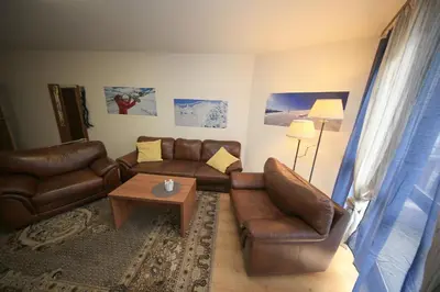 a living room with leather couches and a coffee table at Nice and quiet apartment next to Gondola lift. in Bansko