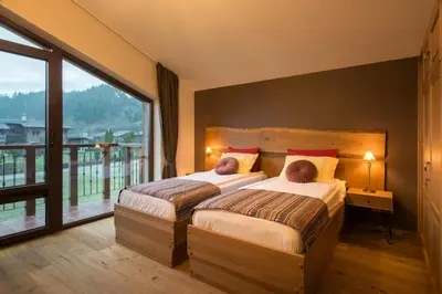 a bedroom with two beds and a large window at Luxury Chalet & Spa Tia Maria with Private SPA in Bansko