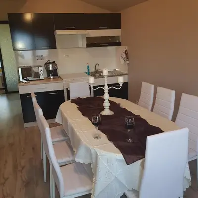 a dining room with a table and white chairs at Guest House Ileana in Sapareva Banya