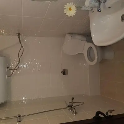a bathroom with a toilet paper dispenser and a sink at Guest House Ileana in Sapareva Banya