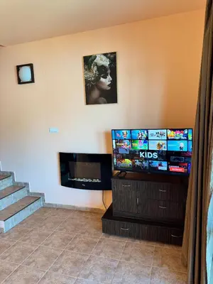 a living room with a tv and a staircase at VIP Complex in Sarnitsa