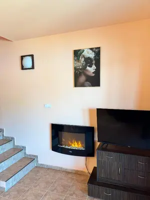 a living room with a fireplace and a staircase at VIP Complex in Sarnitsa