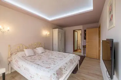 a bedroom with a bed and a flat screen tv at Villa ADELHEIDE - Spa, BBQ & Jacuzzi in Beli Iskar