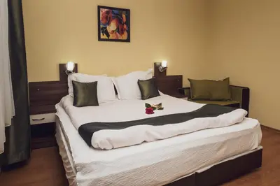 a large bed in a hotel room with a white bedspread at Sky Garden House in Velingrad
