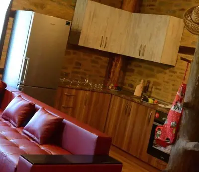 a living room with a red couch and a refrigerator at Dream house in Leshten