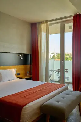 a hotel room with a large bed and a balcony at Adella Boutique Hotel - Free Secured Parking in Sofia
