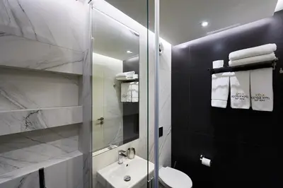 a bathroom with a sink and a glass shower at Adella Boutique Hotel - Free Secured Parking in Sofia