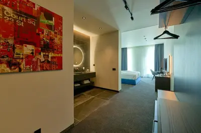 a hotel room with a bedroom and a bed at Adella Boutique Hotel - Free Secured Parking in Sofia