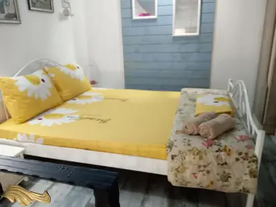 a bedroom with a yellow bed with flowers on it at Cosy House in Sofia