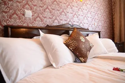 a bedroom with a bed with white pillows at Park Hotel Ribaritsa in Ribarica