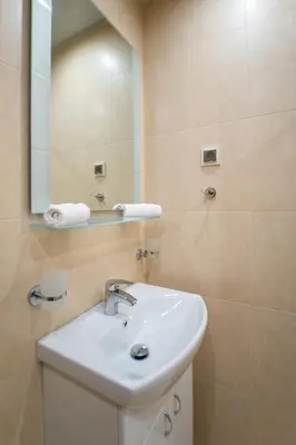 a bathroom with a sink and a mirror at Апартамент АВА in Sandanski