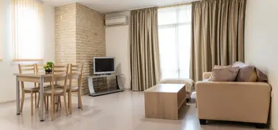 a living room with a couch and a table and a dining room at Апартамент АВА in Sandanski