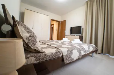a hotel room with a bed and a television at Апартамент АВА in Sandanski