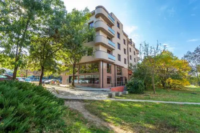 a tall building with trees in front of it at CityHome Aparthotel in Sofia