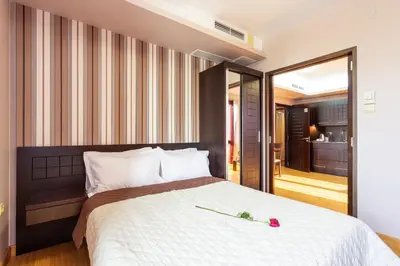 a bedroom with a large bed and a balcony at CityHome Aparthotel in Sofia