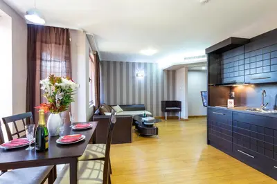 a kitchen and a living room with a table and a living room at CityHome Aparthotel in Sofia