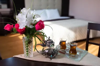 a table with a vase of flowers and two candles at CityHome Aparthotel in Sofia
