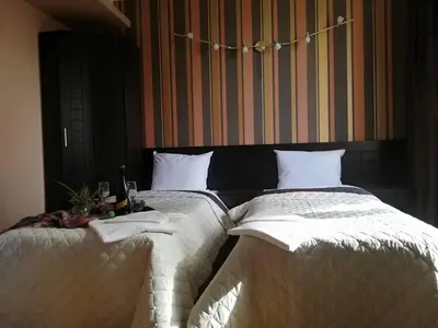 a bedroom with two beds with white comforters at CityHome Aparthotel in Sofia