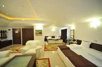 a bedroom with a bed and a living room at Hotel Melnik Хотел Мелник in Melnik