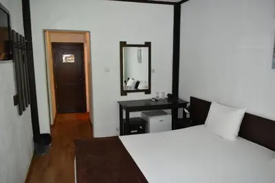 a bedroom with a bed and a desk and a mirror at Hotel Melnik Хотел Мелник in Melnik