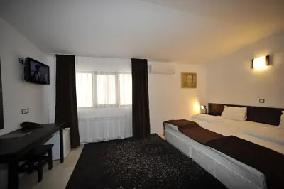 a bedroom with a bed and a desk and a window at Hotel Melnik Хотел Мелник in Melnik