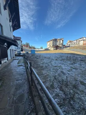 a fence in a field with buildings in the background at Apartment 24 in Pamporovo