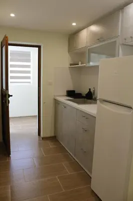 a kitchen with a white refrigerator and a wooden floor at Kamenitza Guest Flat in Plovdiv