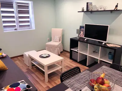 a living room with a television and a table with a bowl of fruit at Kamenitza Guest Flat in Plovdiv