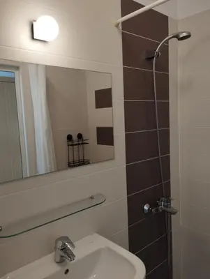 a bathroom with a sink and a mirror and a shower at Top Center Apartment 7 in Sofia