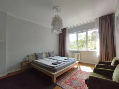 a bedroom with a bed and a couch and a window at Top Center Apartment 7 in Sofia