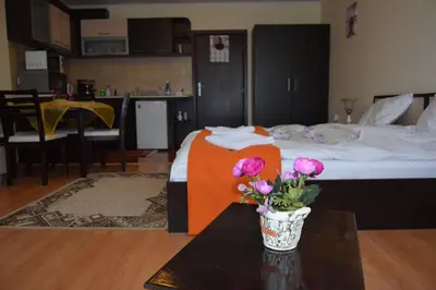 a bedroom with a bed and a table with flowers on it at Elza Apartment in Pamporovo